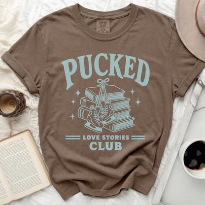 Brown t-shirt with "Pucked Love Stories Club" graphic featuring skates and books.
