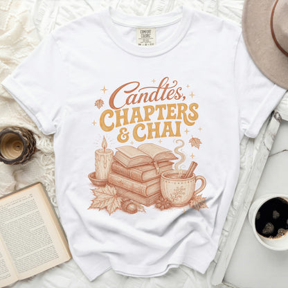 White t-shirt with graphic "Candles, Chapters & Chai" and fall illustrations.