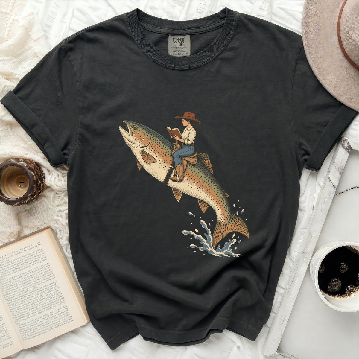 Woman in cowboy hat riding a flying trout reading a book.