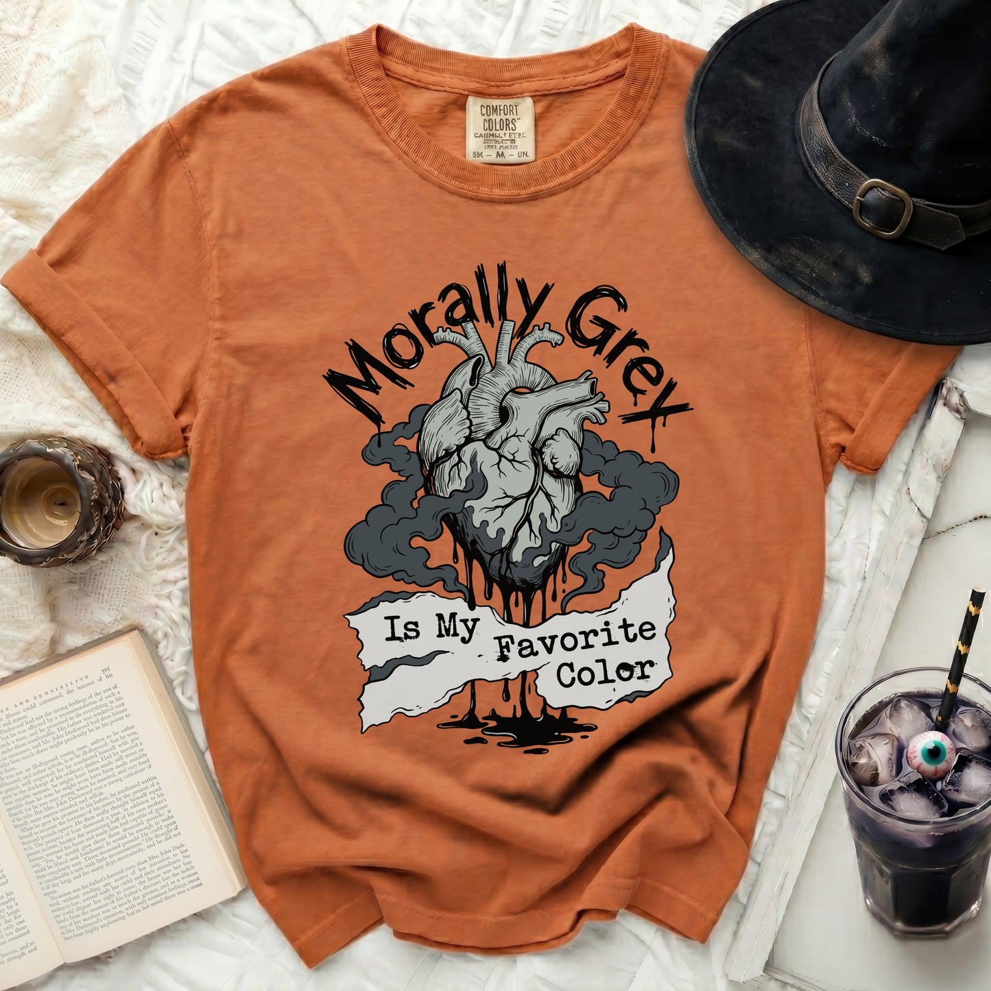 Orange t-shirt with a graphic of a heart and text "Morally Grey Is My Favorite Color".