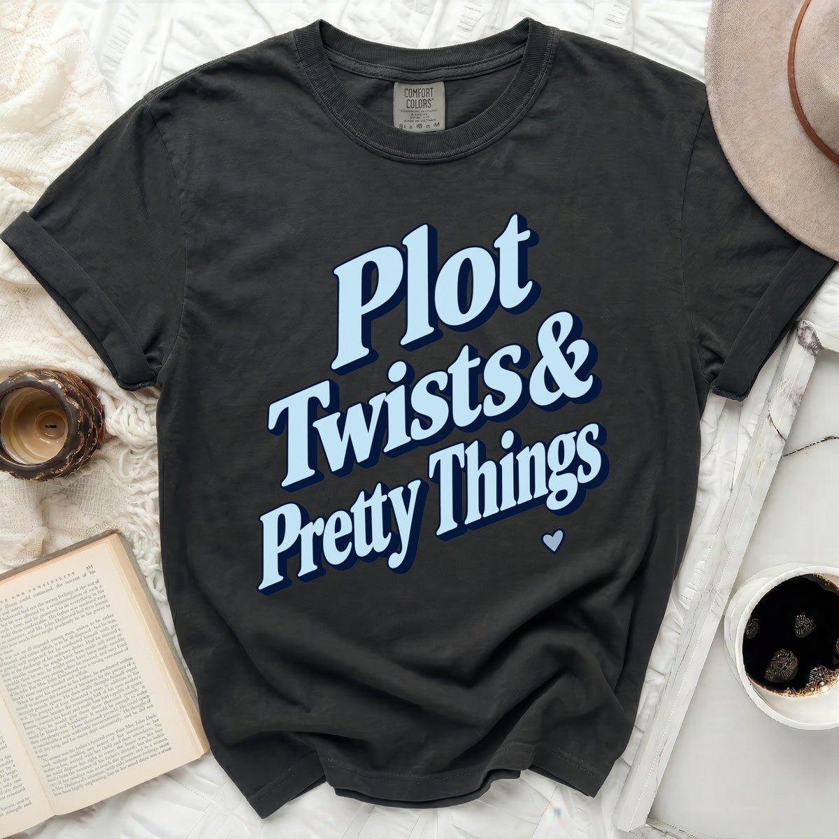 Dark gray t-shirt with light blue text reading "Plot Twists & Pretty Things".