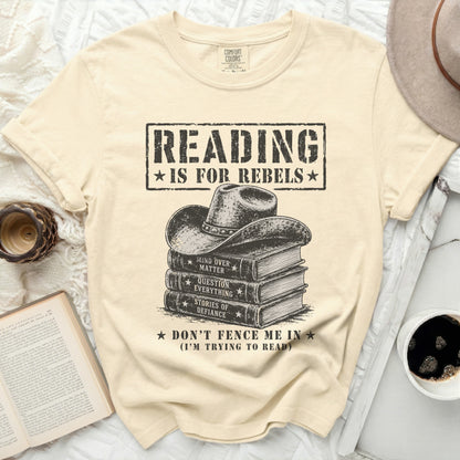 Cream t-shirt with "Reading is for Rebels" and stack of books with cowboy hat.