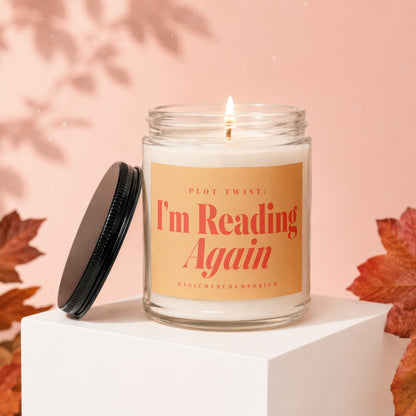 Clear glass candle with orange label reading "Plot Twist: I'm Reading Again."