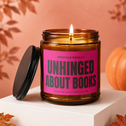 Amber glass candle with pink label saying "Unhinged About Books" and "MagicMerch Emporium".
