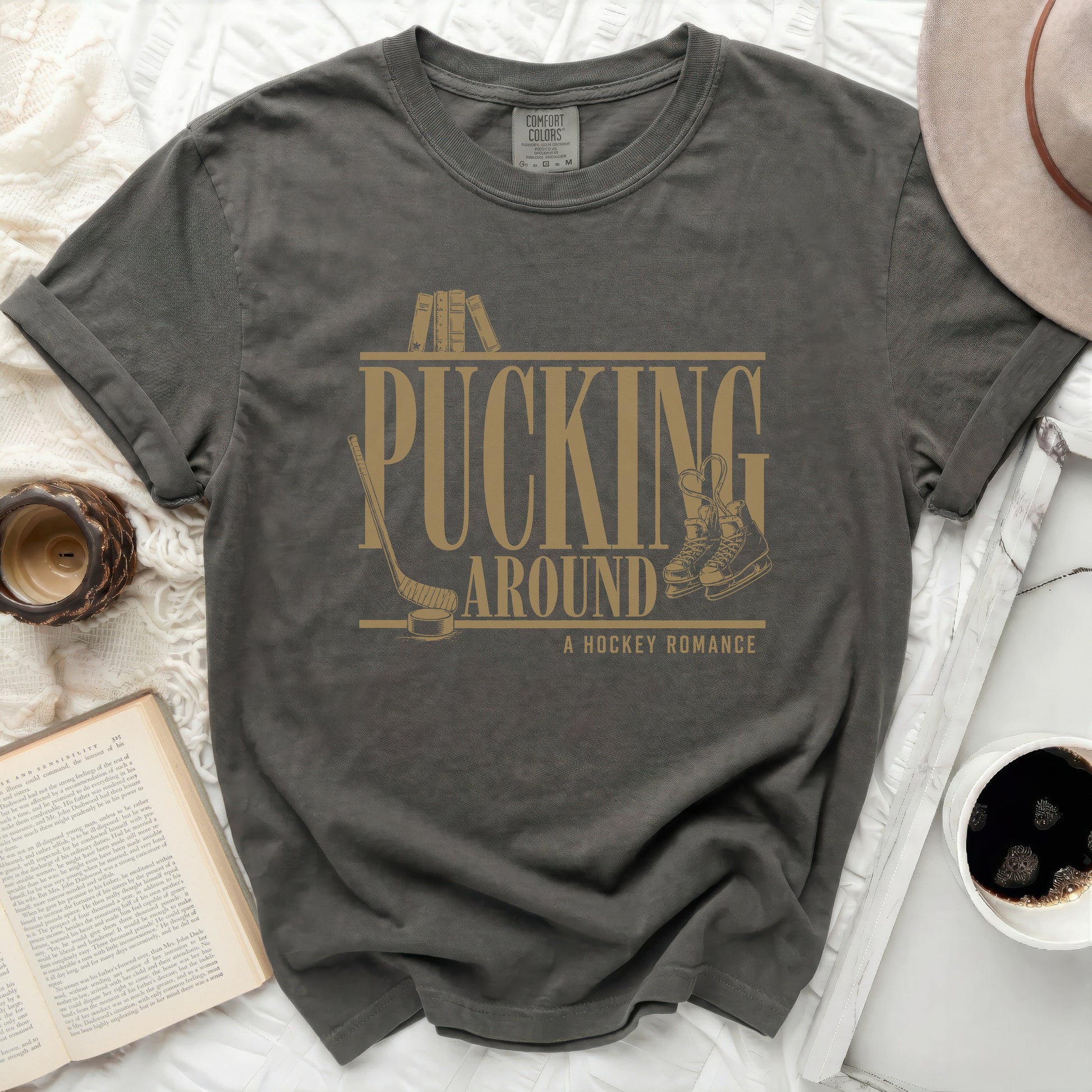 Dark grey t-shirt with "Pucking Around A Hockey Romance" text and hockey skates.