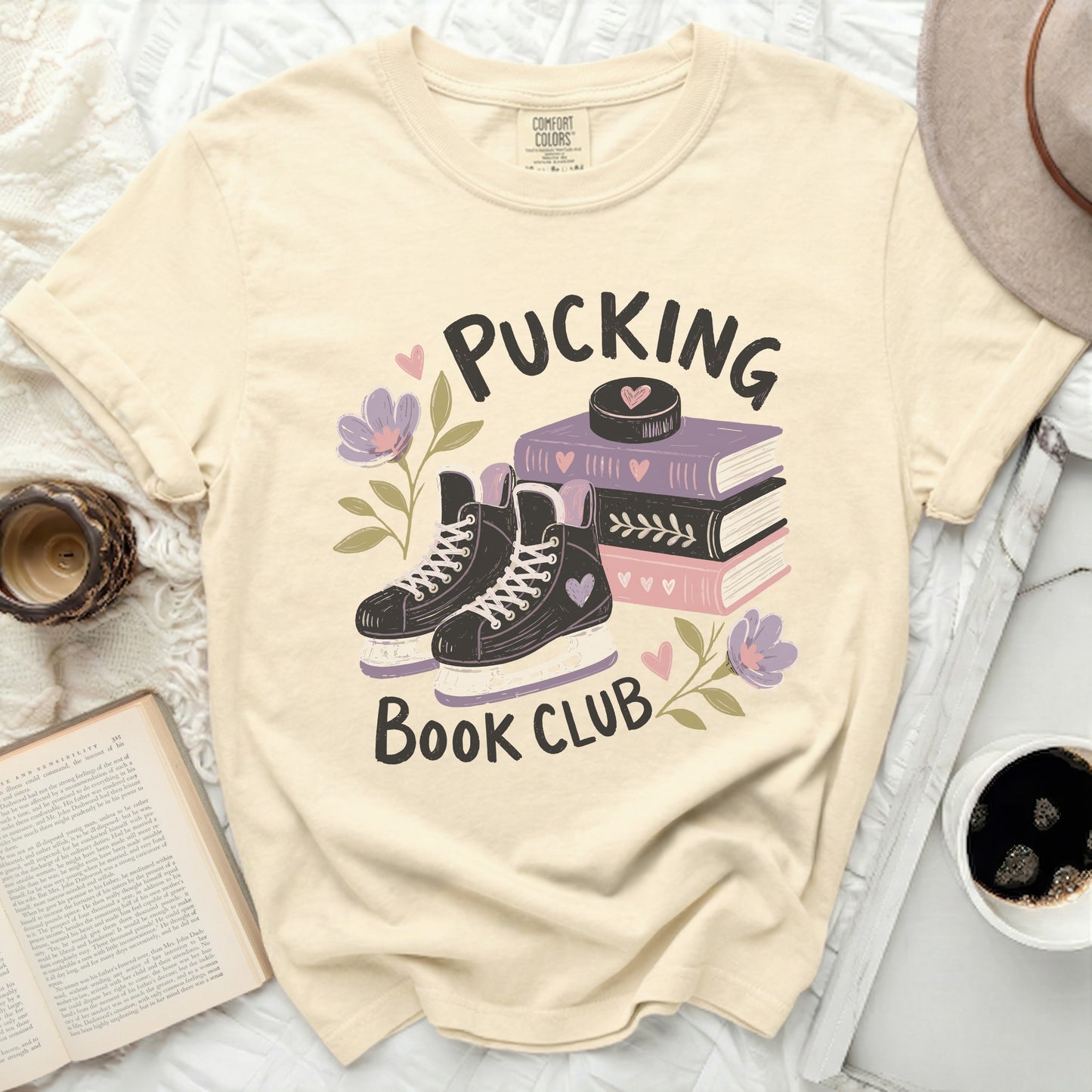 Cream t-shirt with "Pucking Book Club" and hockey skates graphic.
