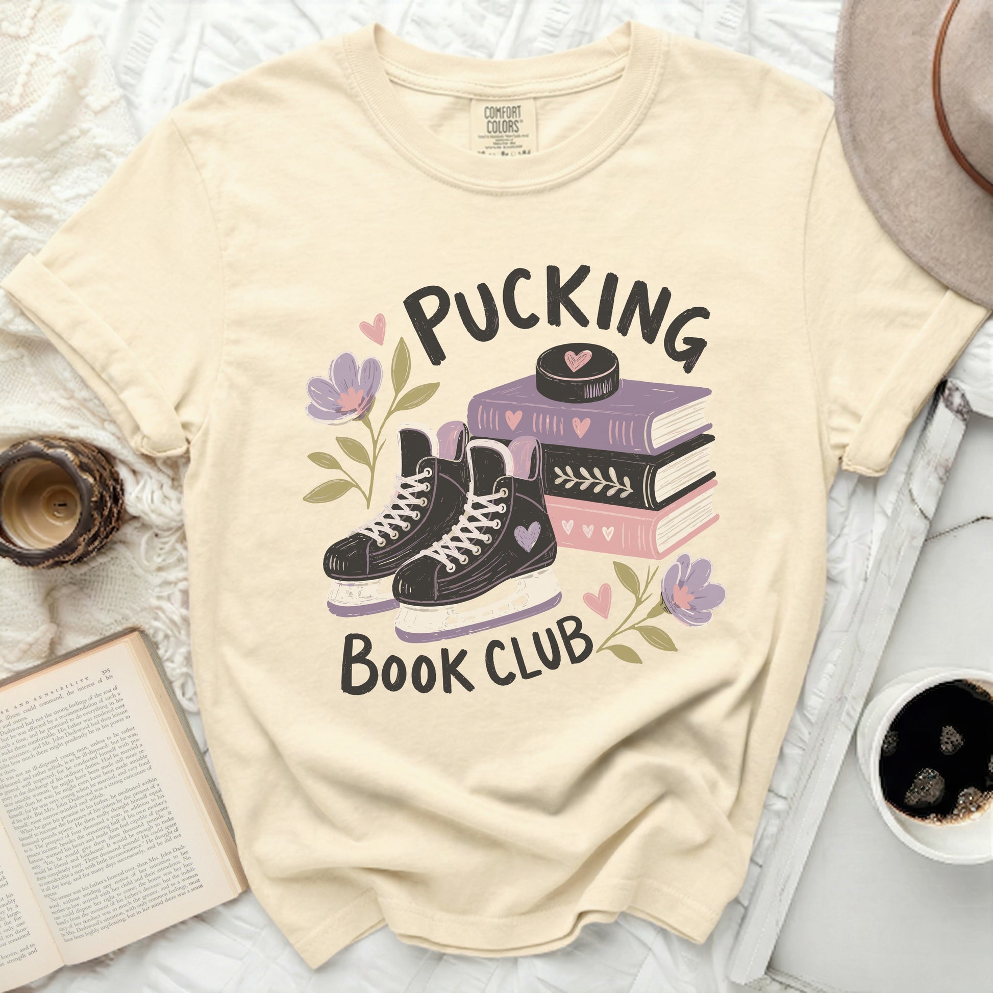 Cream t-shirt with "Pucking Book Club" and hockey skates graphic.