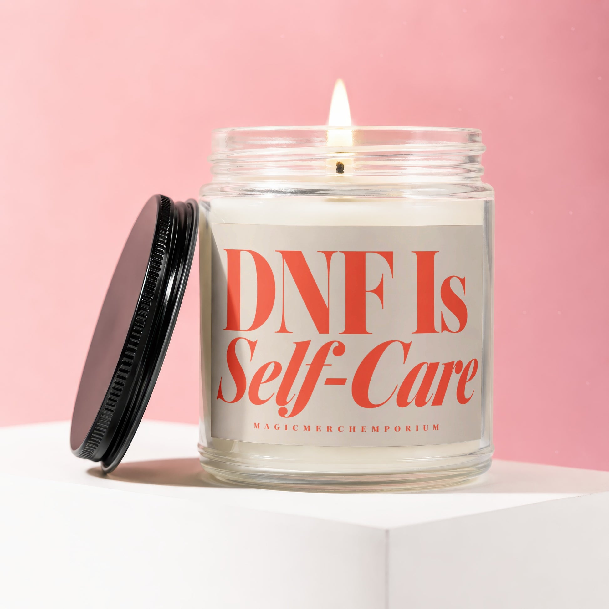 Glass jar candle with lid off, displaying "DNF Is Self-Care" text.