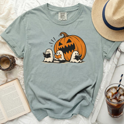 Three white ghosts read books near a jack-o-lantern graphic on a shirt.