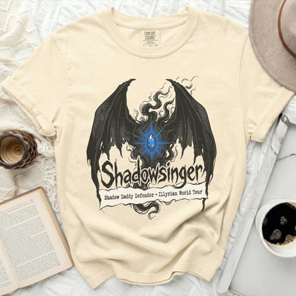 Cream t-shirt with black wings and blue gem, "Shadowsinger" text.