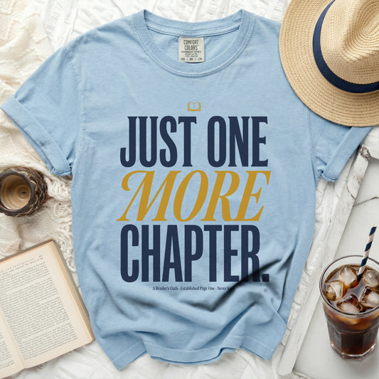 Light blue t-shirt with "JUST ONE MORE CHAPTER" text and a book icon.