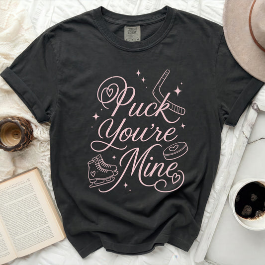 Black t-shirt with pink text "Puck You're Mine" and hockey graphics.