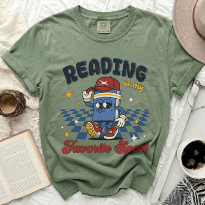 Green t-shirt with a cartoon book graphic and "Reading is my favorite sport" text.