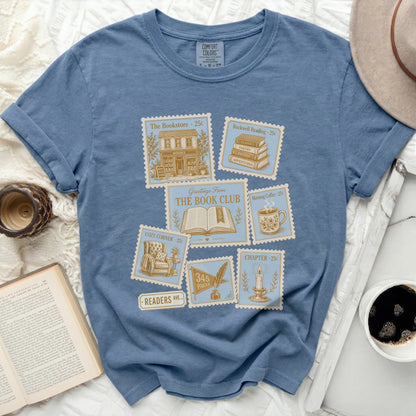 Blue t-shirt with vintage postcard designs for "The Book Club."