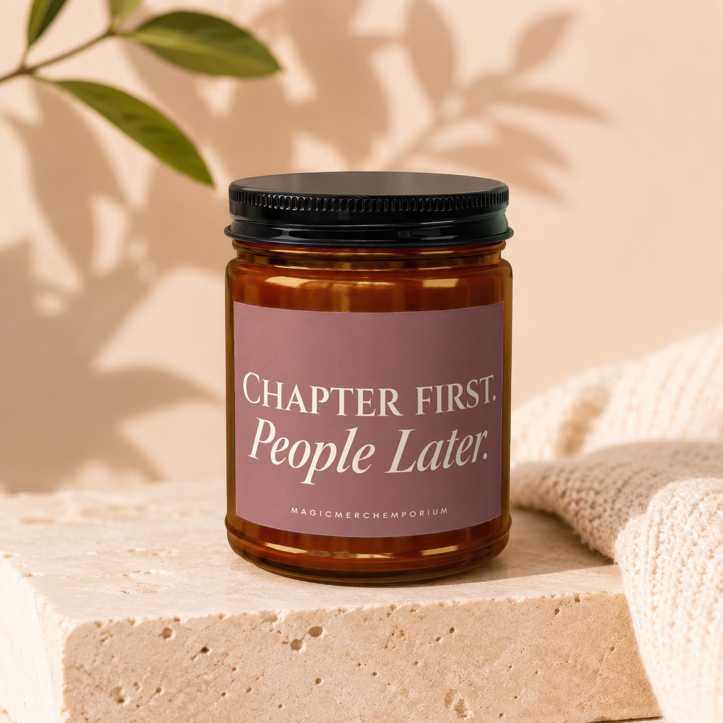 Amber jar candle with black lid displaying "Chapter First. People Later." text.
