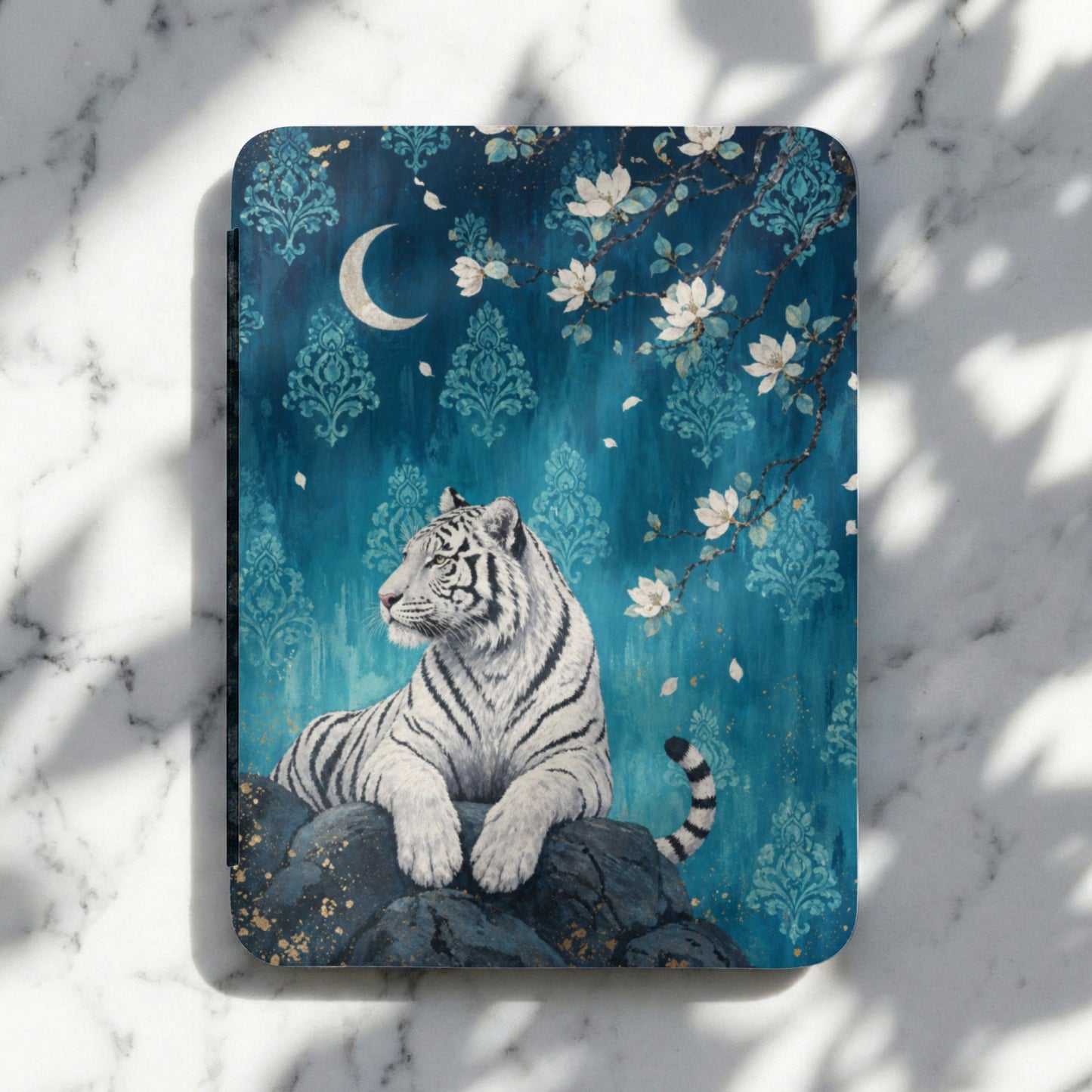 White tiger resting on rocks with moon and floral background.