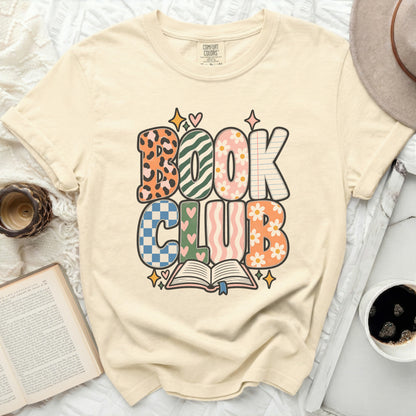 Cream t-shirt with "BOOK CLUB" graphic featuring colorful, patterned letters.