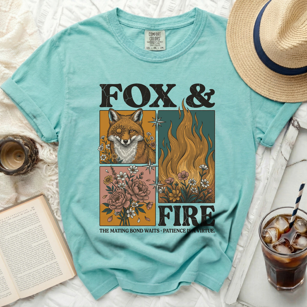 Teal t-shirt with "Fox & Fire" graphic, a fox, flames, and flowers.