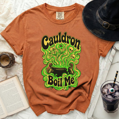 Orange t-shirt with "Cauldron Boil Me" Halloween graphic and black witch hat.
