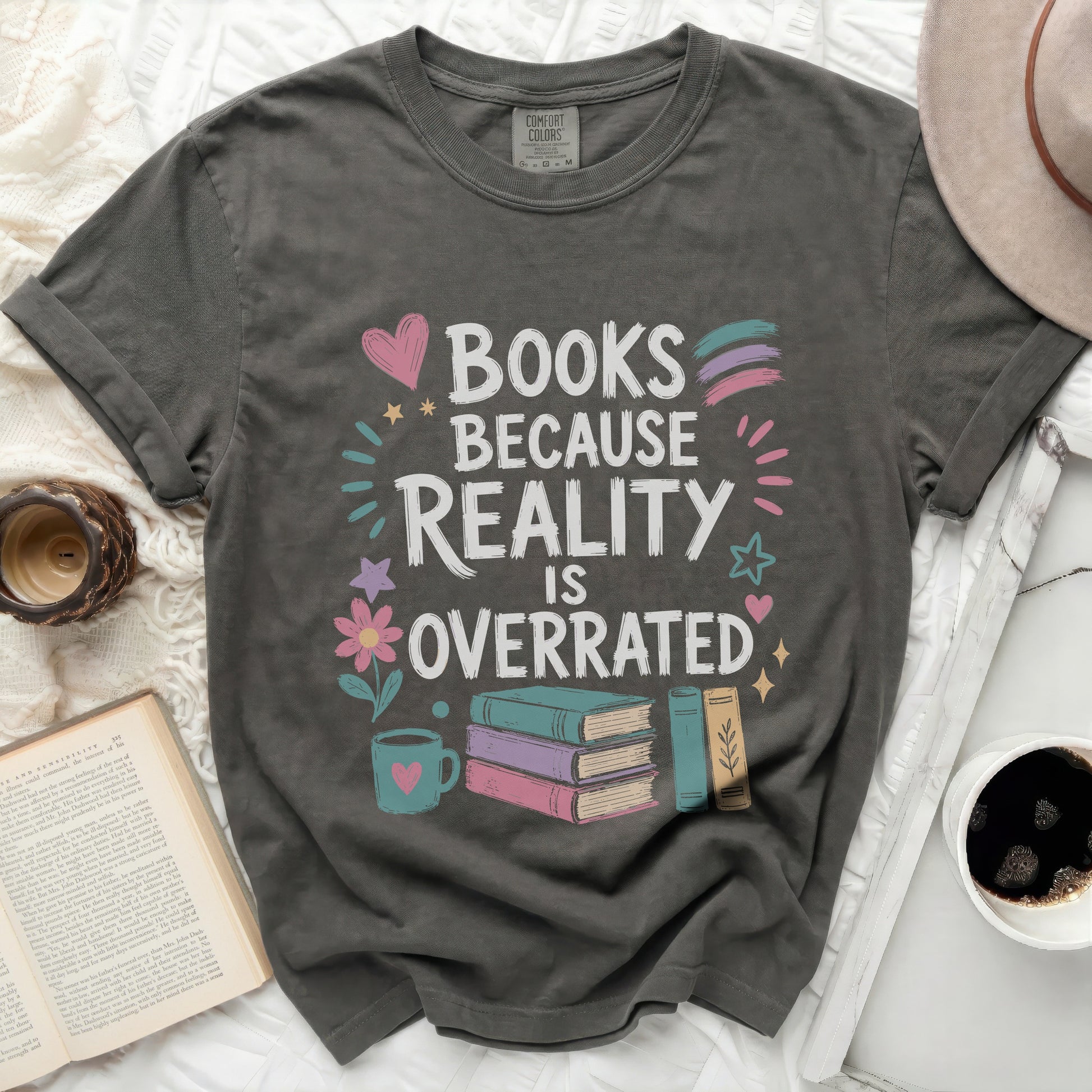 Grey t-shirt with "Books Because Reality Is Overrated" text and illustrations.