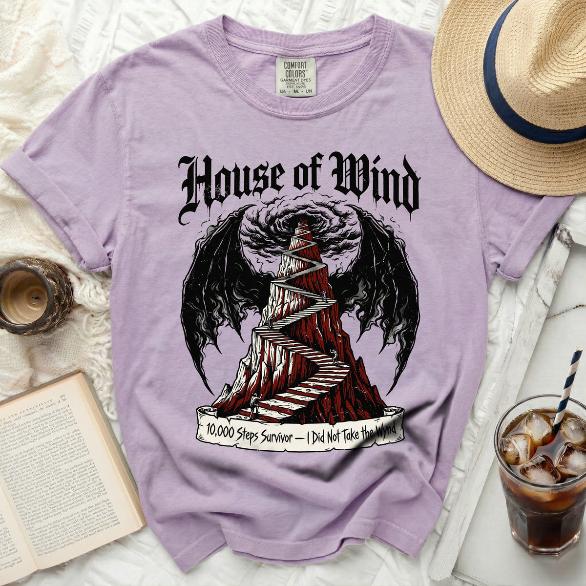 Purple t-shirt with "House of Wind" and winding stairs graphic.