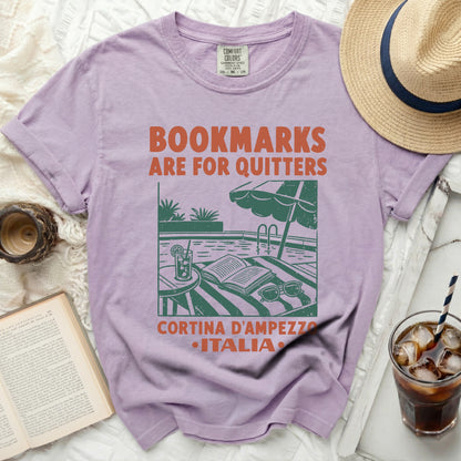 Purple t-shirt with "Bookmarks are for quitters" and pool scene graphic.