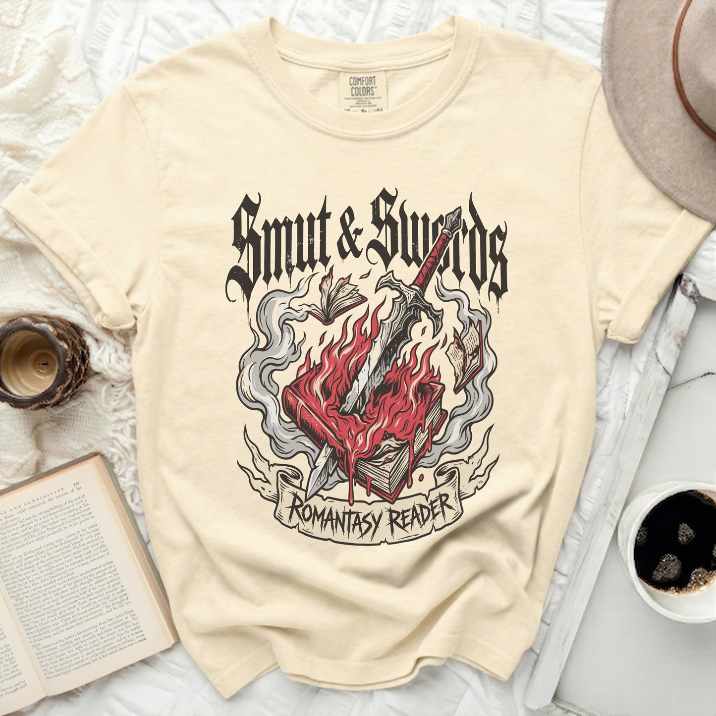 Cream t-shirt with "Smut & Swords Romantasy Reader" graphic of burning book and sword.