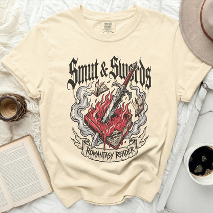 Cream t-shirt with "Smut & Swords Romantasy Reader" graphic of burning book and sword.