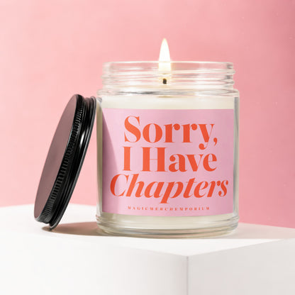 Candle in glass jar with burned wick and "Sorry, I Have Chapters" text on pink label.