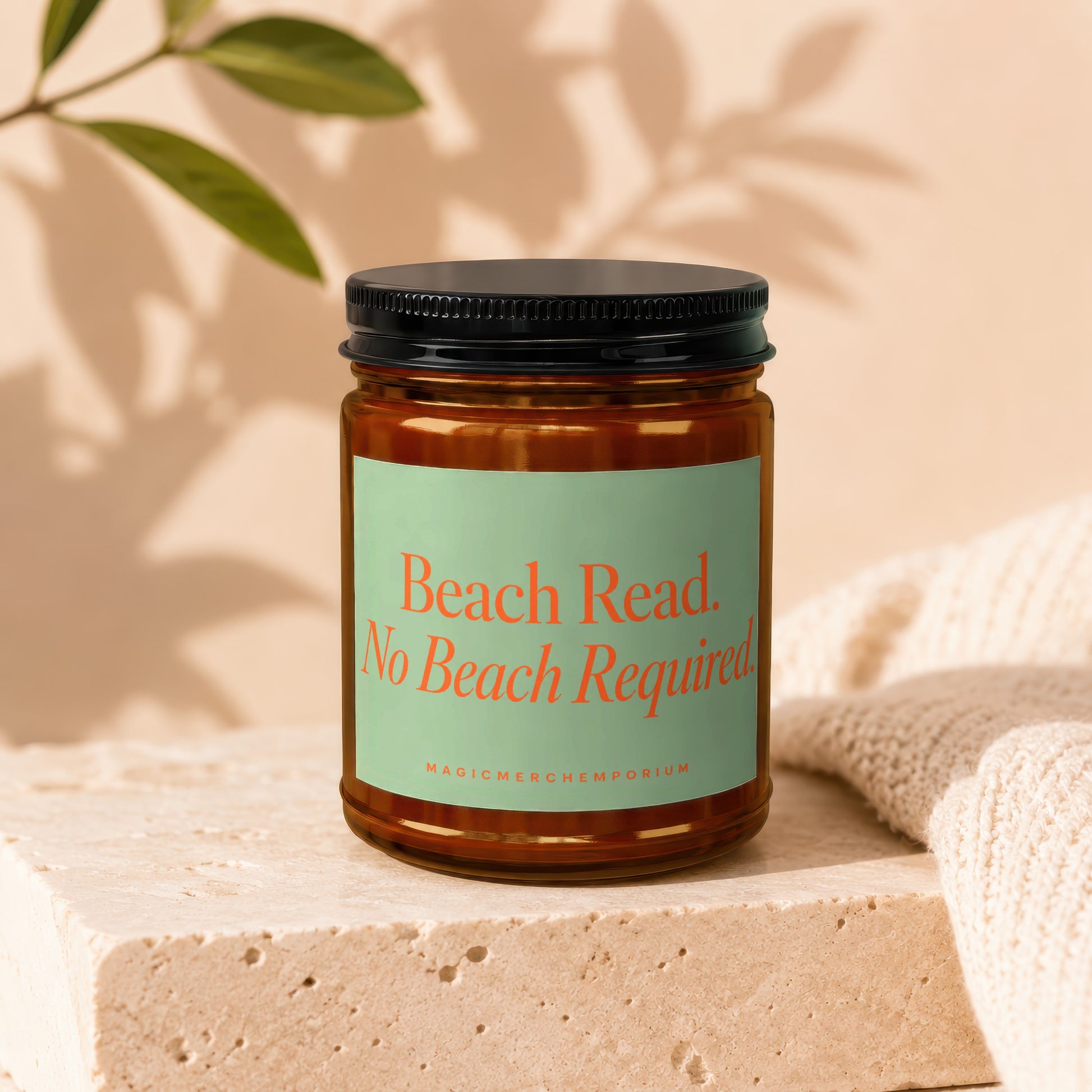Amber jar candle with a mint green label reading "Beach Read. No Beach Required. MAGICMERCHEMPORIUM"