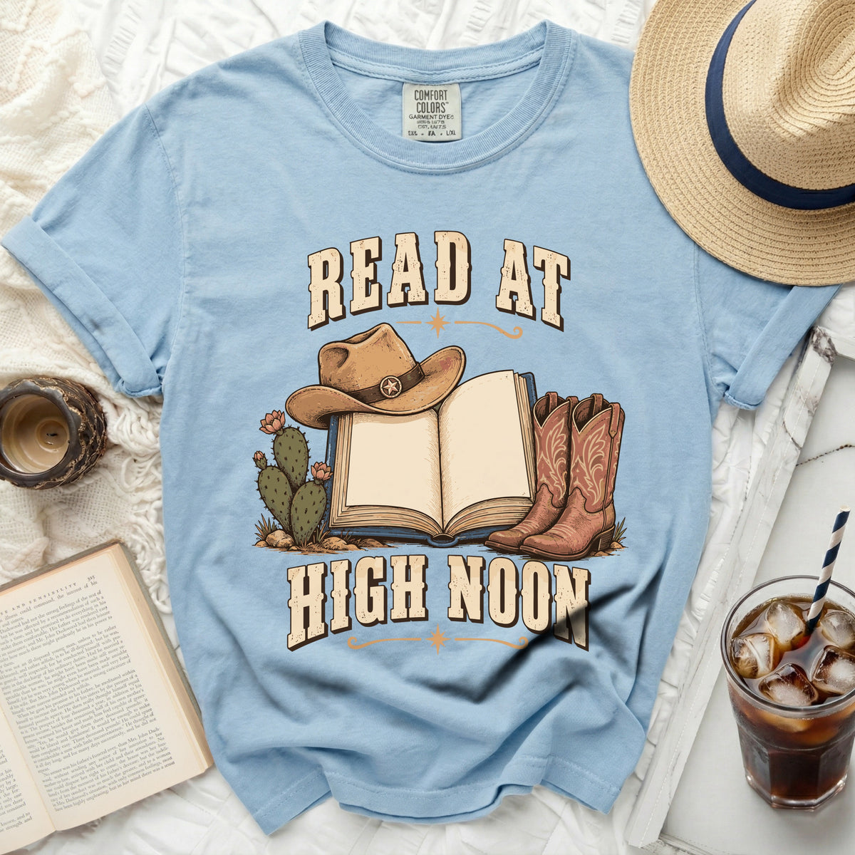 Light blue t-shirt with "READ AT HIGH NOON" text, cowboy hat, boots, and cactus graphic.