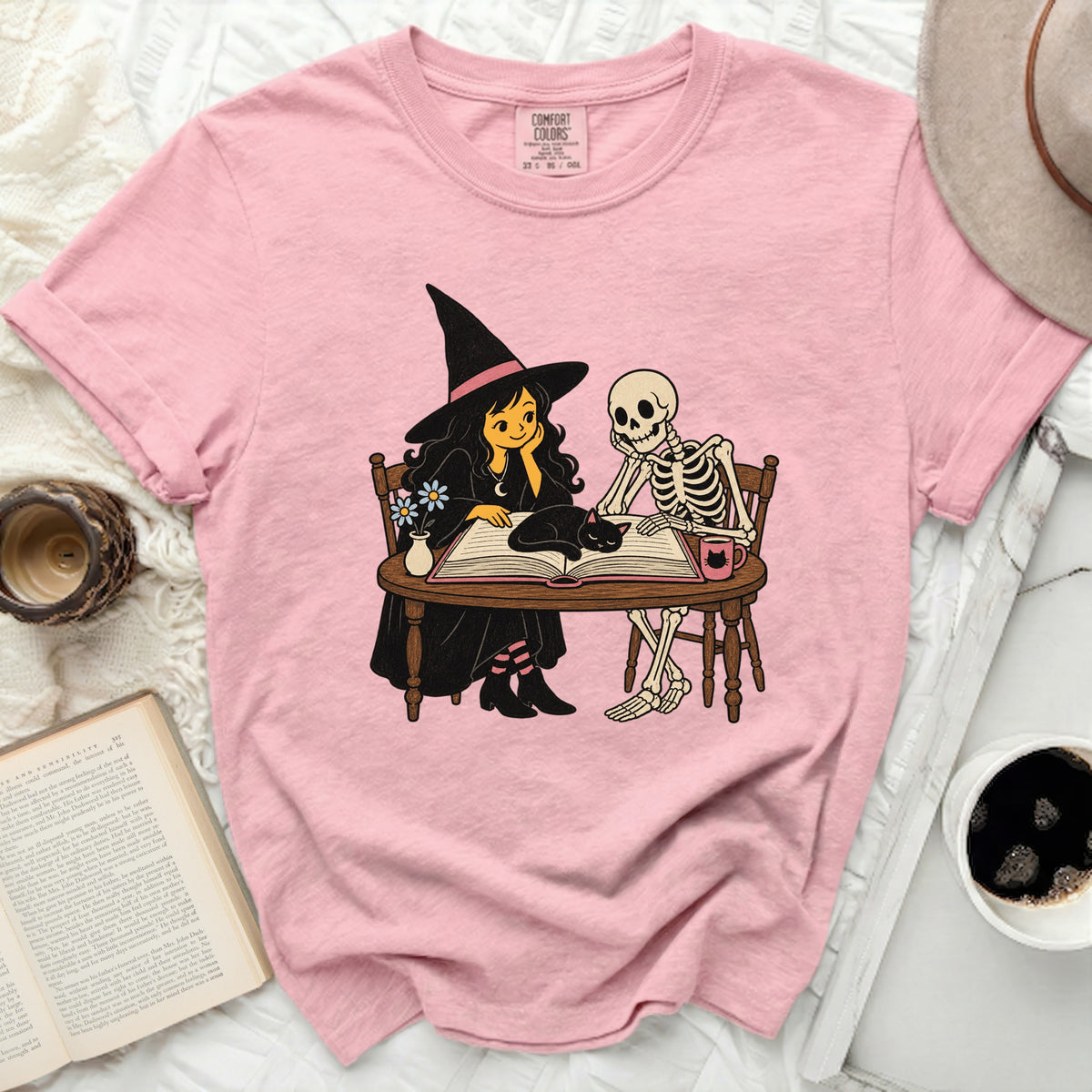 Witch and skeleton reading a book with a black cat.