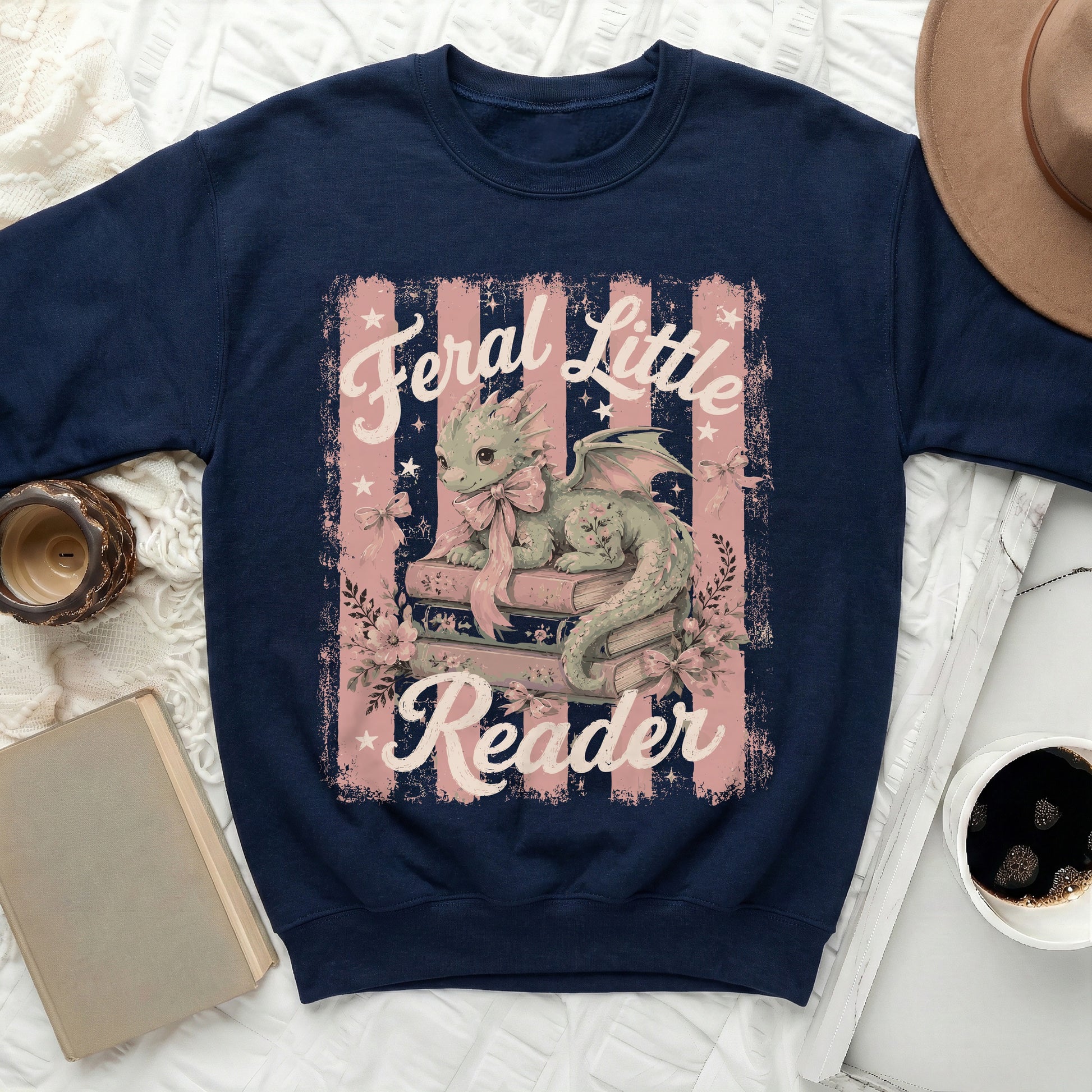 Navy sweatshirt with a green dragon reading books, "Feral Little Reader" text.