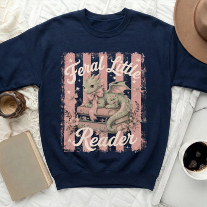 Navy sweatshirt with a green dragon reading books, "Feral Little Reader" text.