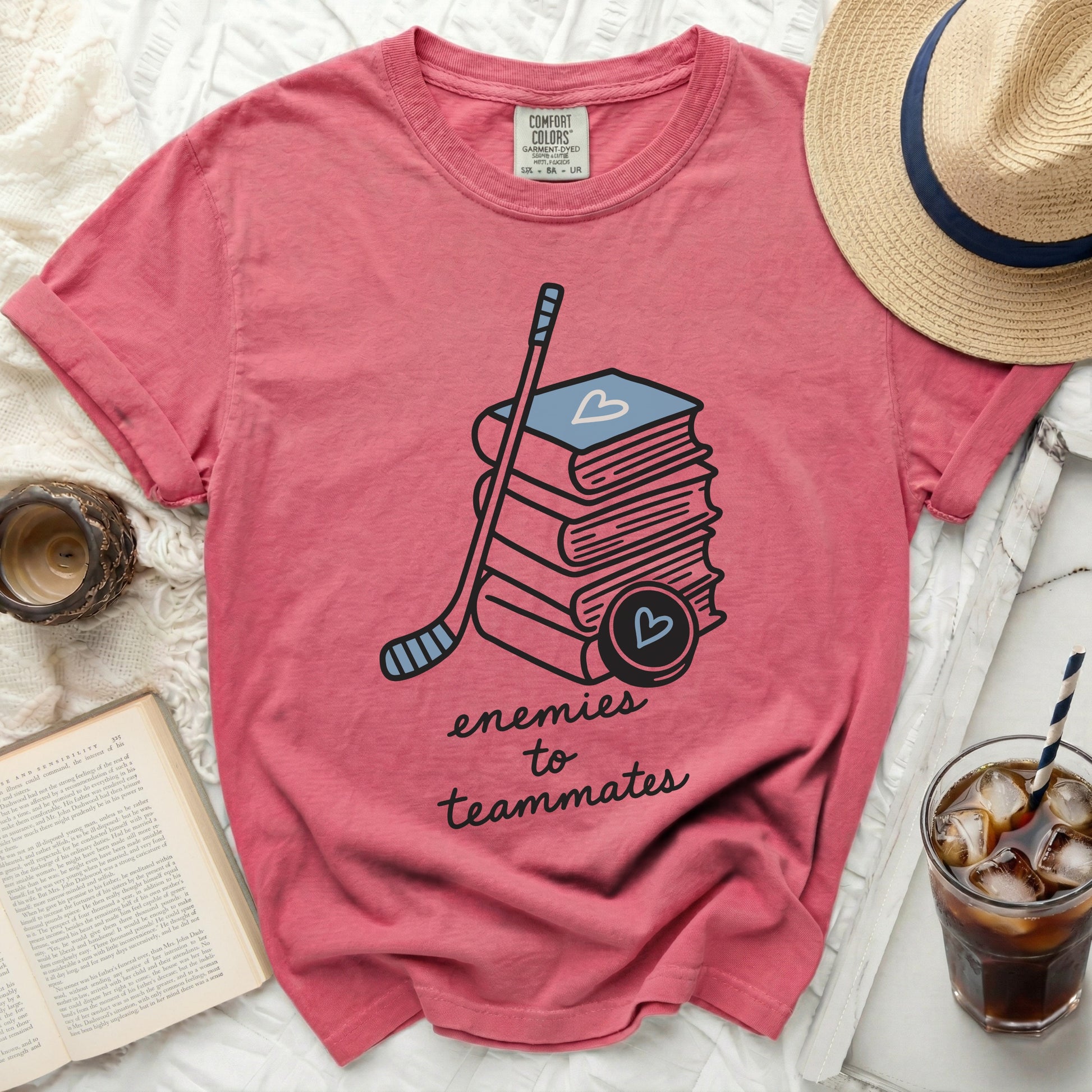 Pink t-shirt with books, hockey stick, and "enemies to teammates" text.