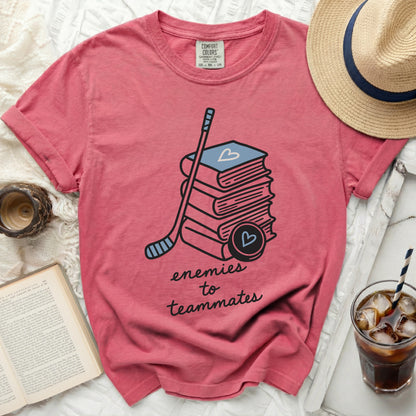 Pink t-shirt with books, hockey stick, and "enemies to teammates" text.