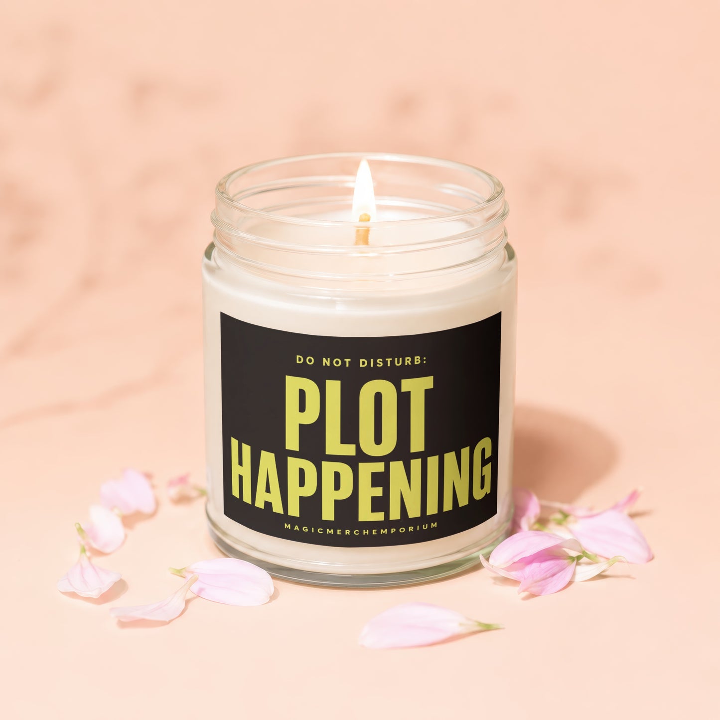 Candle in glass jar with black label reading "DO NOT DISTURB: PLOT HAPPENING".