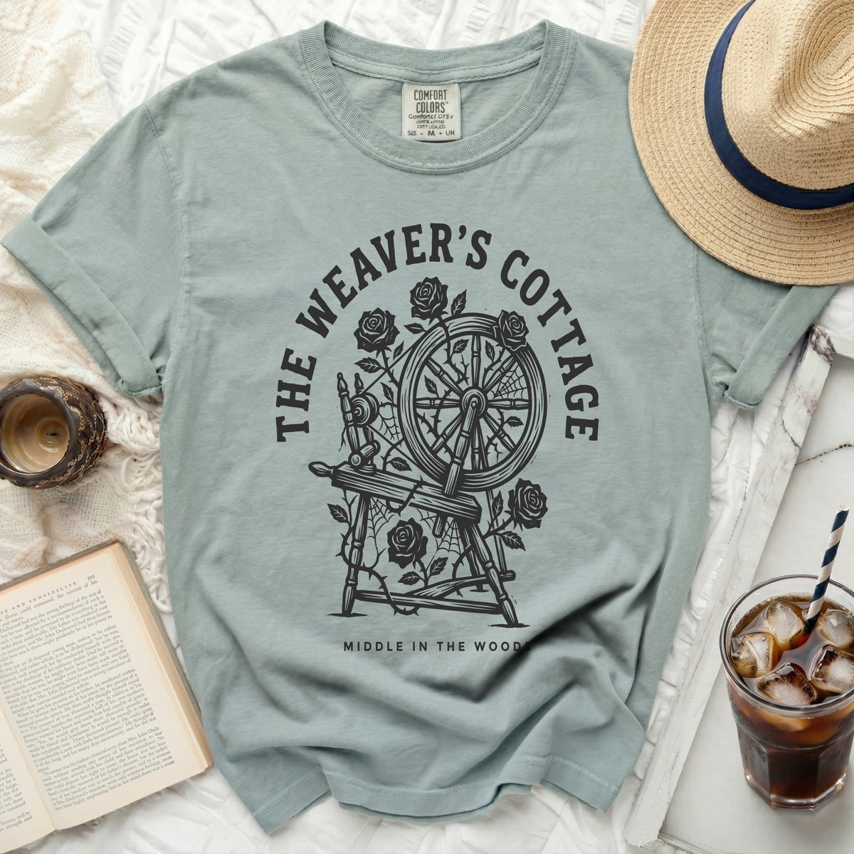 Pale blue t-shirt with "The Weaver's Cottage" and spinning wheel graphic.