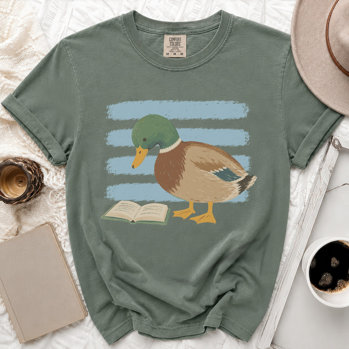 Mallard duck with green head reading a book on a green t-shirt.