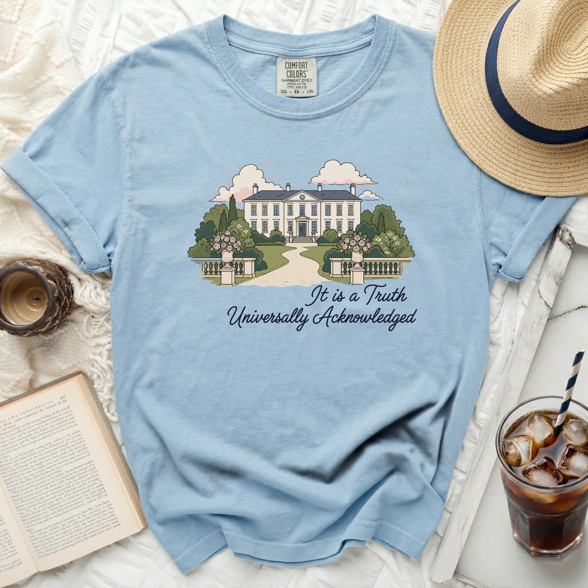 Light blue t-shirt with a house and garden illustration and quote.