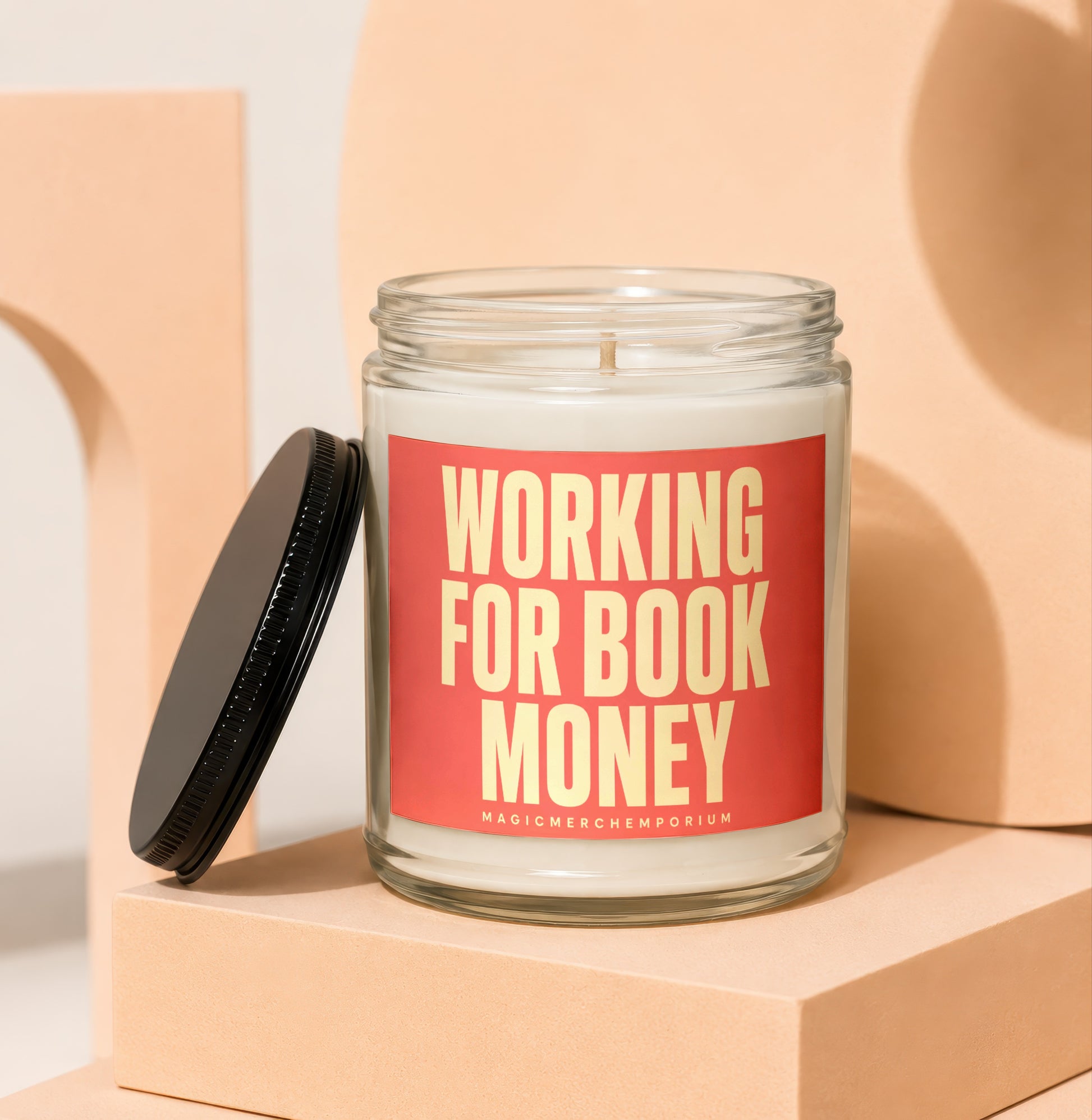 Glass candle with red label reading "WORKING FOR BOOK MONEY"
