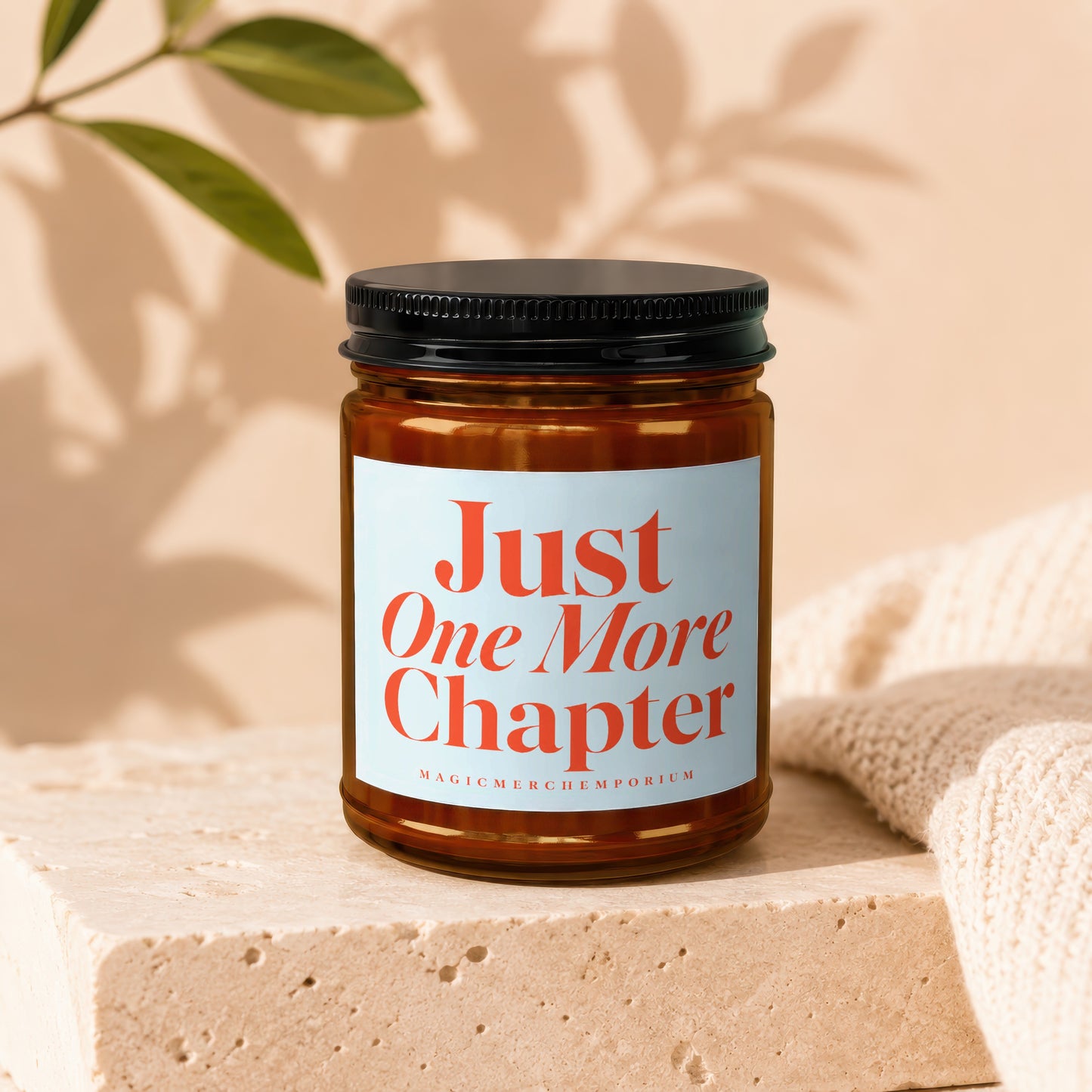 Candle with "Just One More Chapter" text and MagicMerchEmporium logo.