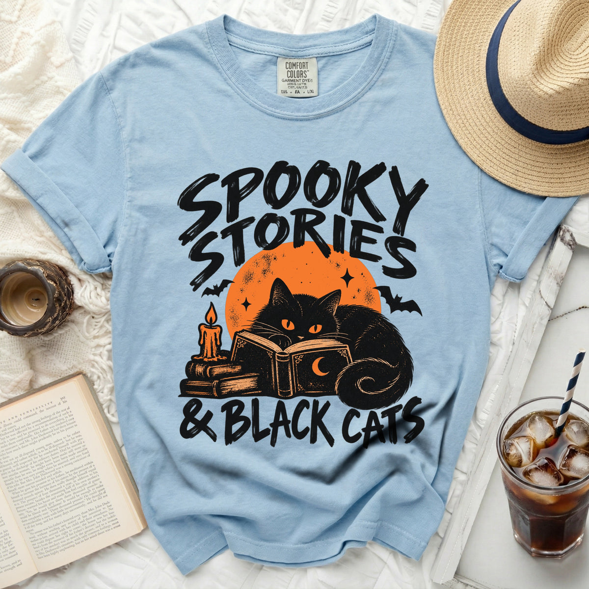 Light blue t-shirt with "Spooky Stories & Black Cats" graphic featuring a black cat reading.