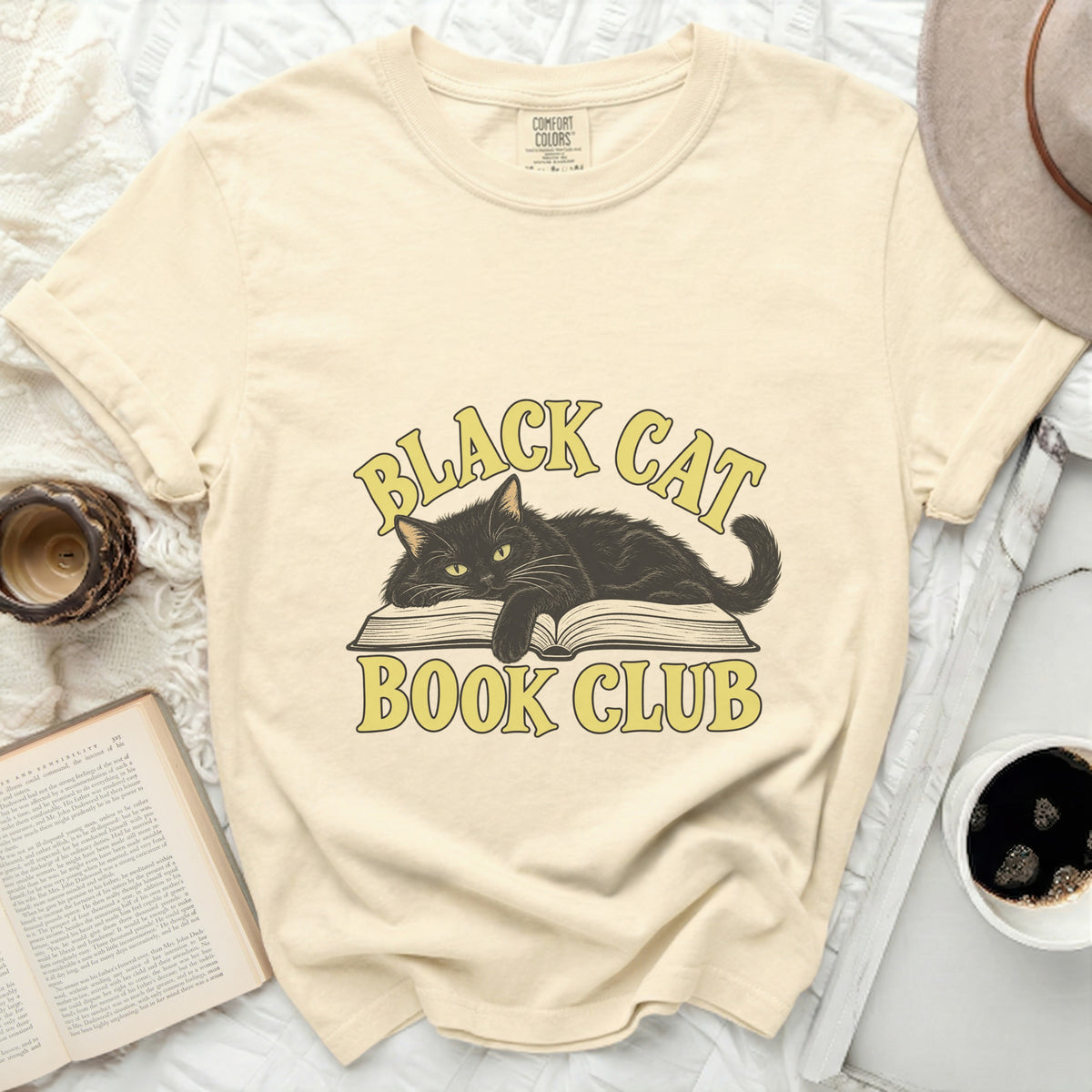 Cream t-shirt with black cat on open book, "Black Cat Book Club" text.