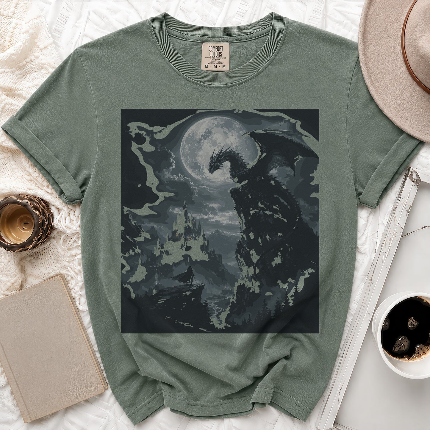 Green t-shirt with a dark dragon and castle graphic under a moon.