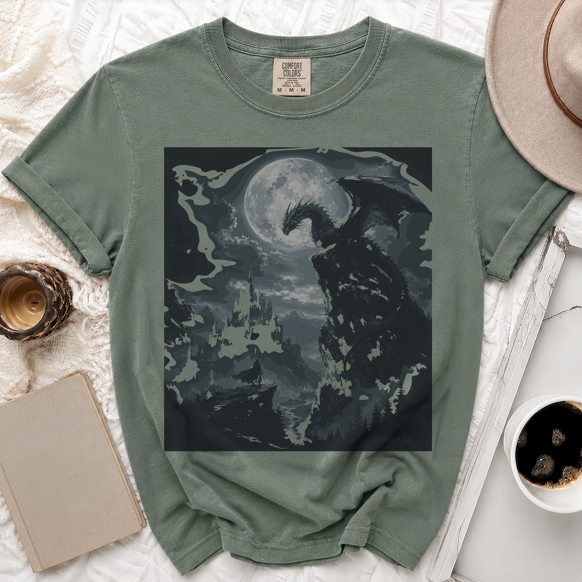 Green t-shirt with a dark dragon and castle graphic under a moon.