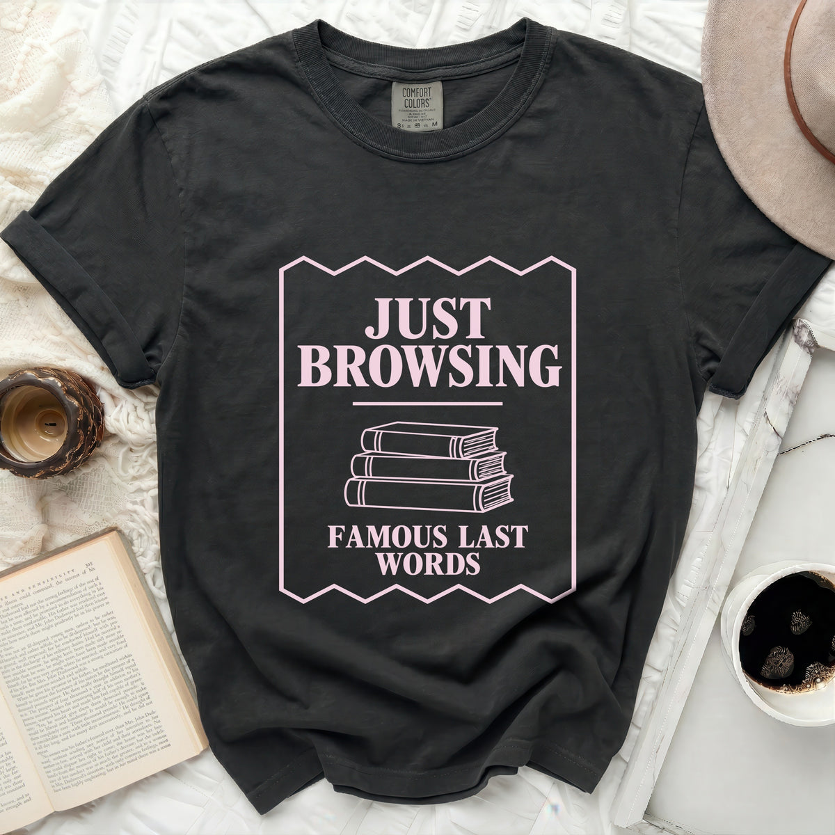Dark grey t-shirt with "JUST BROWSING FAMOUS LAST WORDS" text and stacked books graphic.