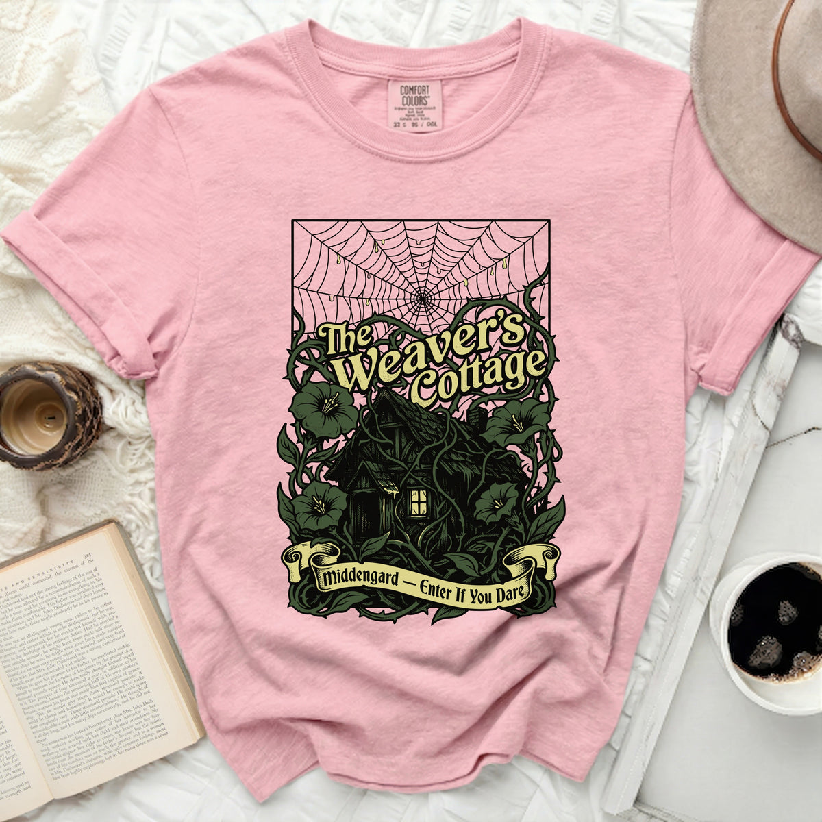 Pink t-shirt with "The Weaver's Cottage" and "Middengard - Enter If You Dare" graphic.