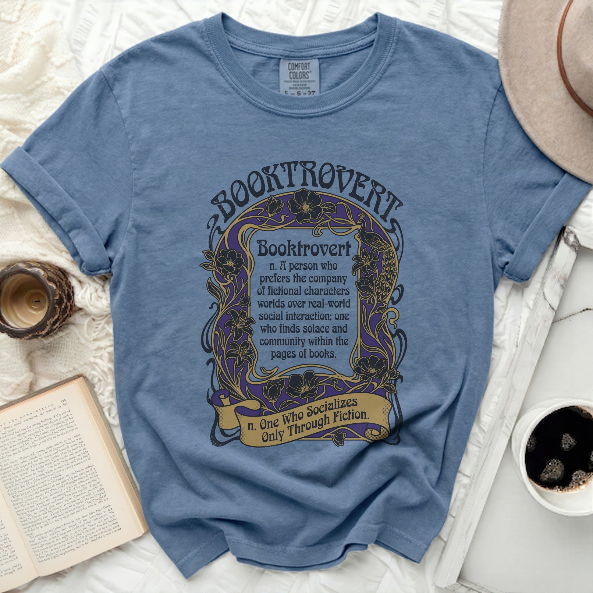 Blue t-shirt with "Booktrovert" definition and floral border design.