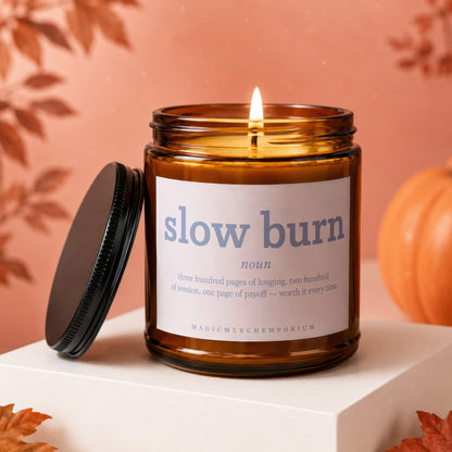 Burning candle labeled "slow burn" with a definition and autumn decor.